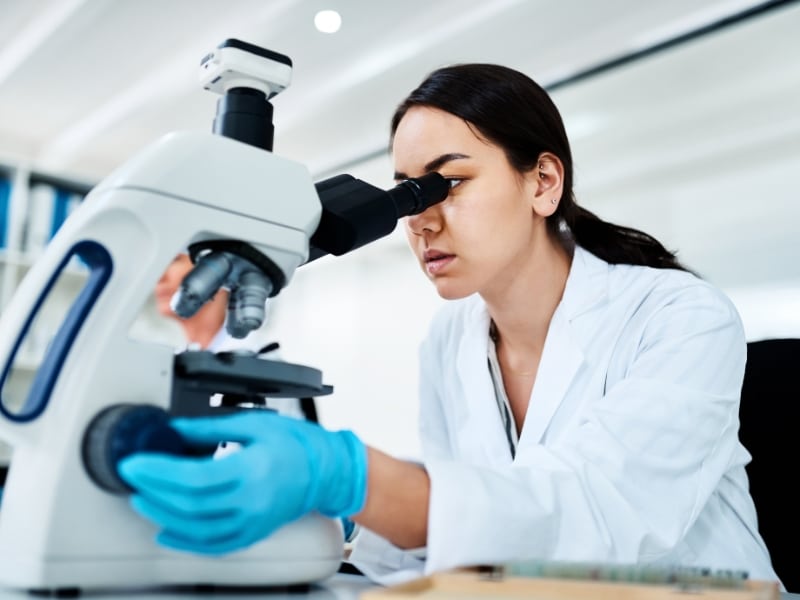 Image of an organic chemist looking through a microscope.